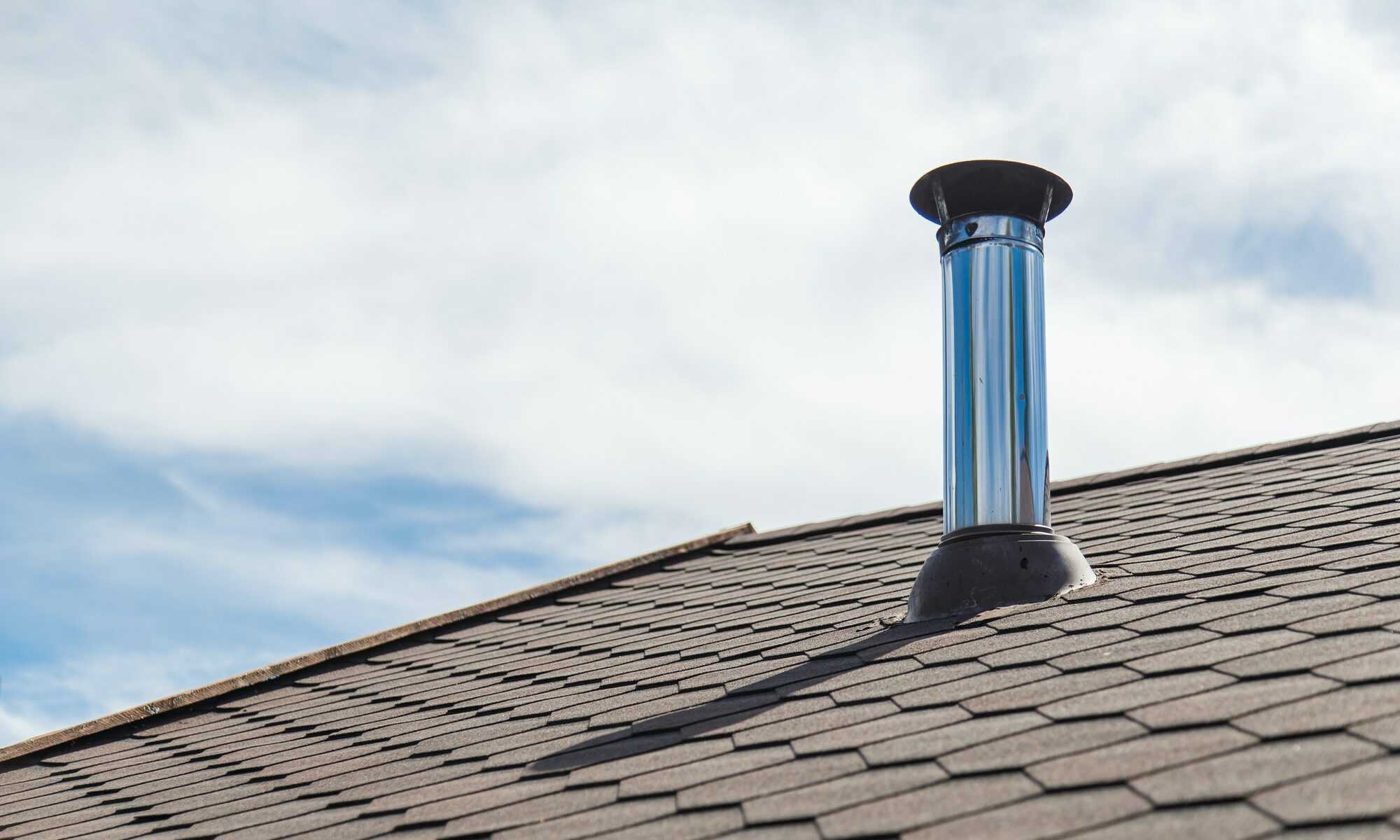 Chimney pipe from stainless steel on the roof of the house